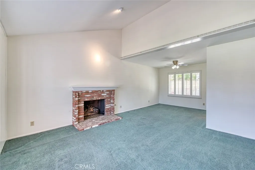 Living room with cozy fireplace flows seamlessly into the dining room.