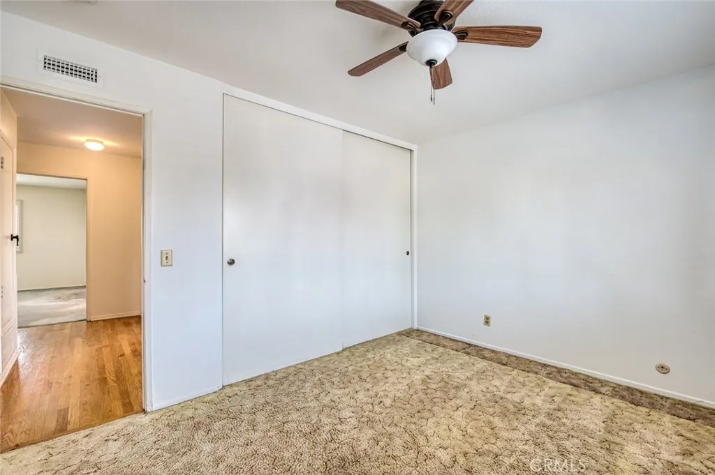 Third upstairs bedroom with ceiling fan and spacious closet.