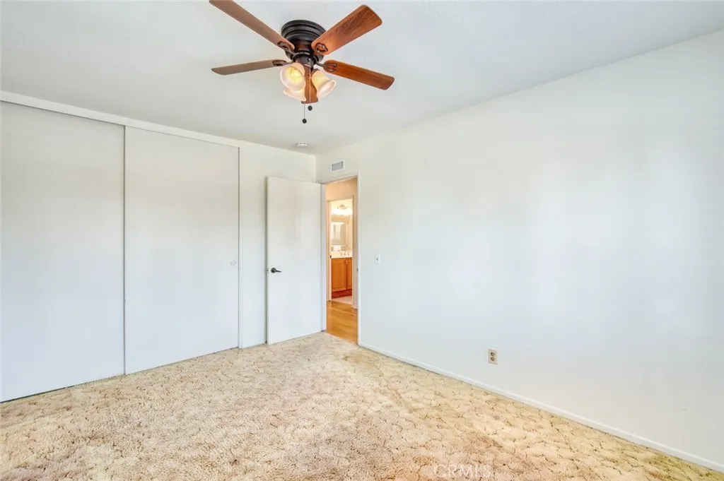 Second upstairs bedroom with ceiling fan and spacious closet.
