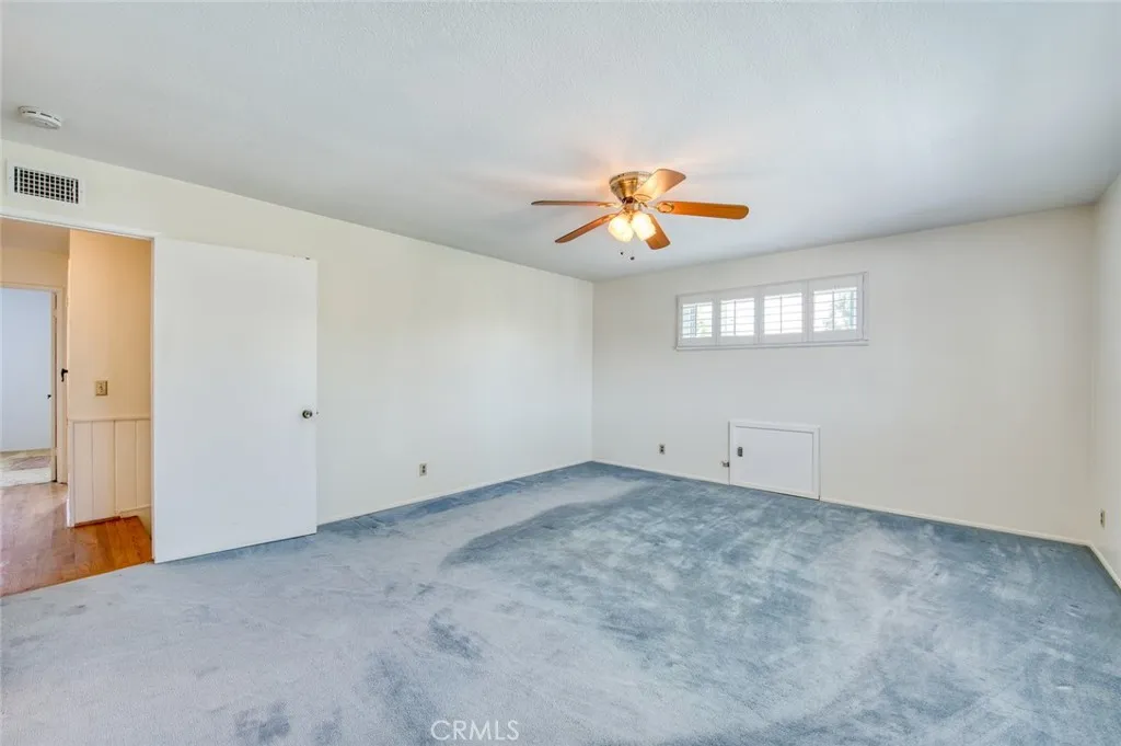Spacious upstairs primary suite featuring a ceiling fan and ample natural light.