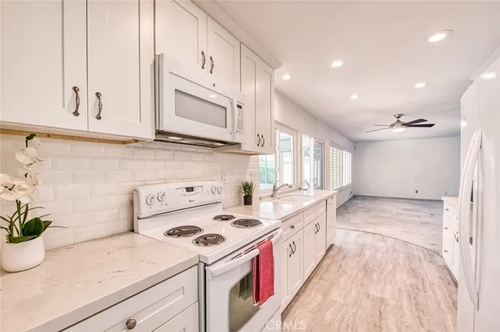 Remodeled kitchen featuring elegant quartz countertops, custom cabinetry, and generous storage space opens to the family room.