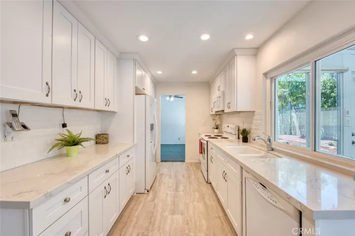 Professional kitchen featuring elegant quartz countertops, custom cabinetry, and generous storage space throughout.