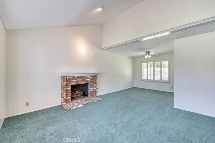 Living room with cozy fireplace flows seamlessly into the dining room.