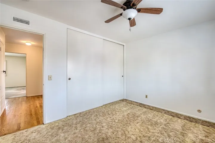 Third upstairs bedroom with ceiling fan and spacious closet.