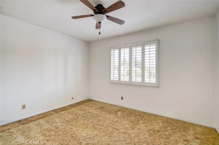 Third upstairs bedroom with ceiling fan and spacious closet.