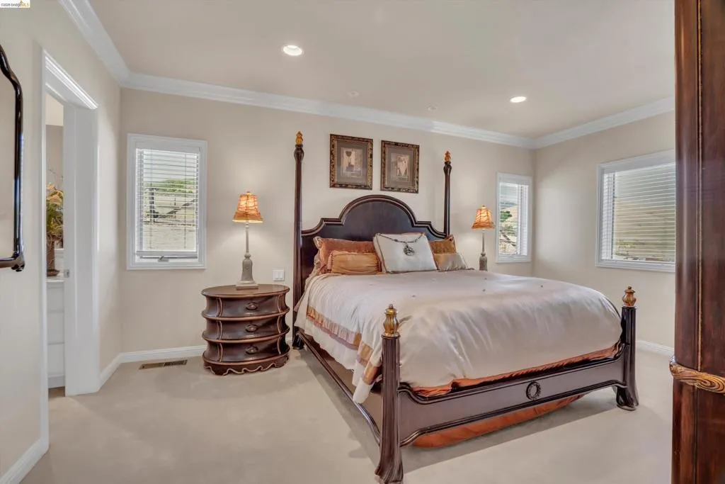 Neutral-toned room featuring beige carpeting and white crown molding
