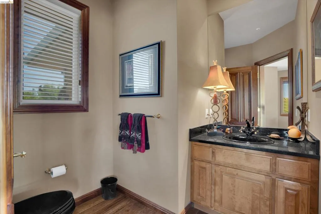Bathroom featuring a wood-finish vanity with a dark countertop and integrated sink