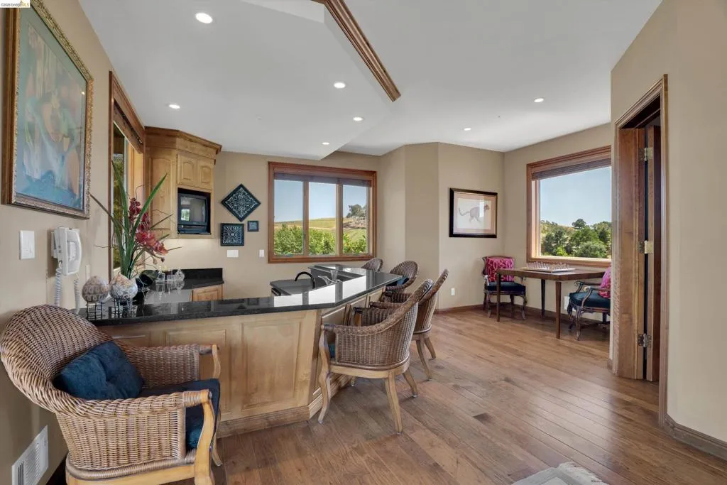 Spacious entertainment area featuring wood-finish flooring and recessed lighting