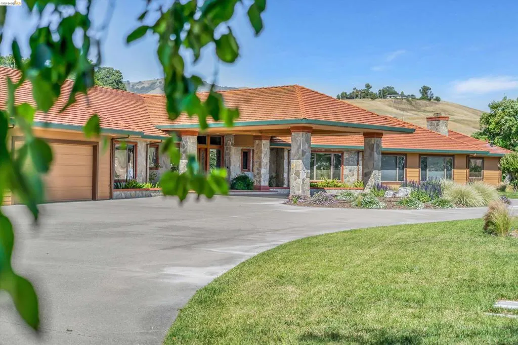 The property features an expansive circular driveway leading to a stone-clad portico entry