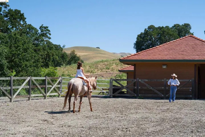 Expansive outdoor riding arena with a wood fence perimeter