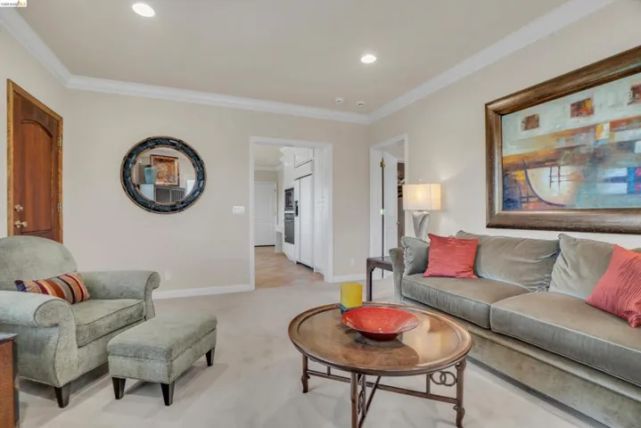 Neutral-toned walls with recessed lighting and crown molding