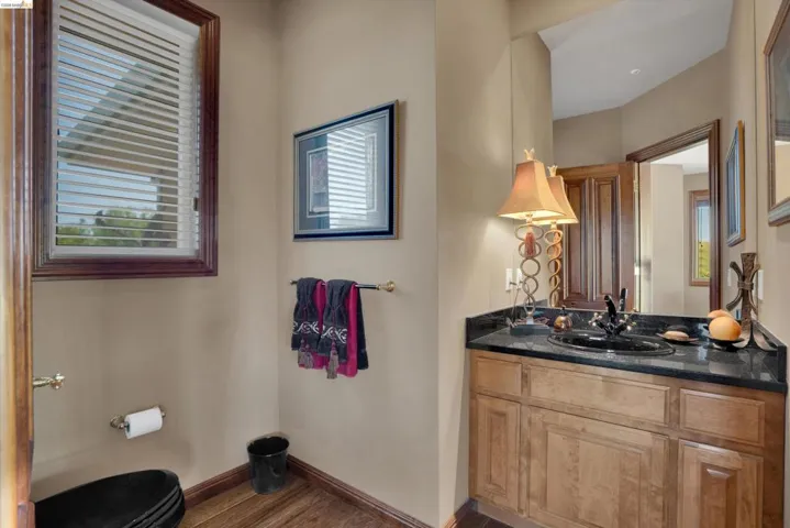 Bathroom featuring a wood-finish vanity with a dark countertop and integrated sink