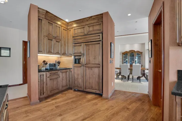 Wood-finish flooring throughout, complemented by custom wood cabinetry and integrated appliances