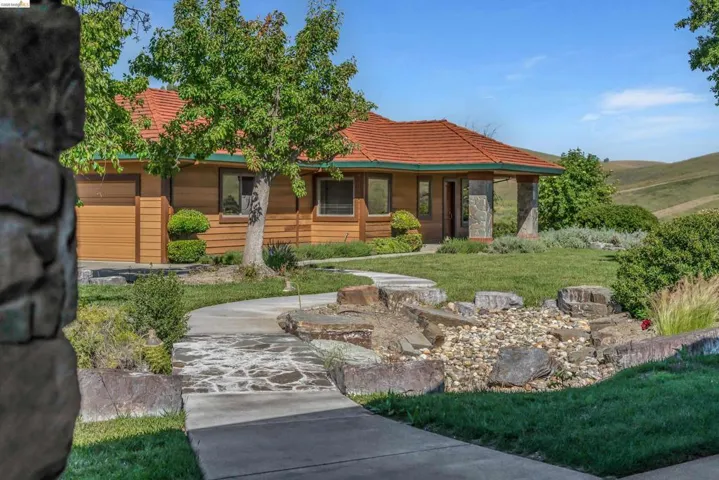 Exterior featuring a red tile roof, wood siding, and stone accents