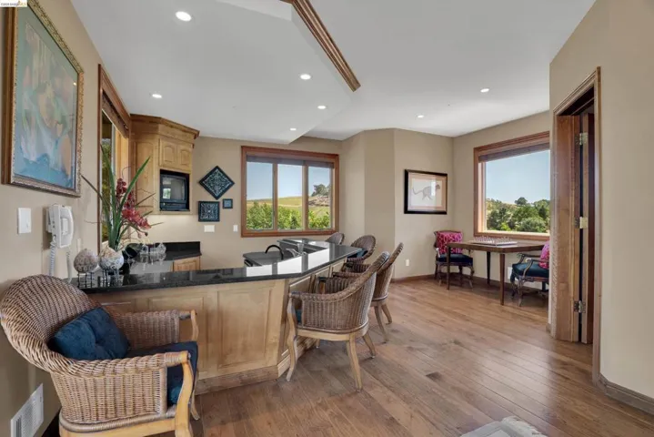 Spacious entertainment area featuring wood-finish flooring and recessed lighting