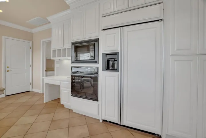 White paneled appliances integrated within extensive cabinetry