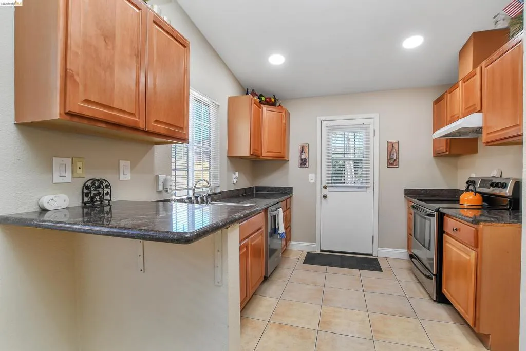 Kitchen featuring light wood cabinetry with dark countertops