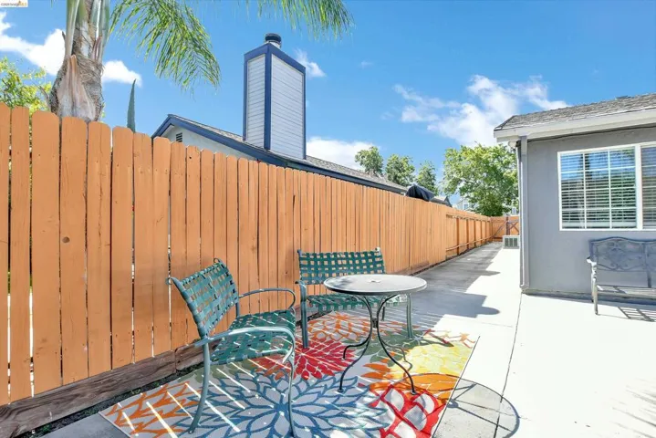 Private side yard featuring a wood fence and concrete patio