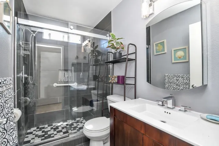 Shower with dark grey subway tile, glass enclosure, and a mosaic tile floor