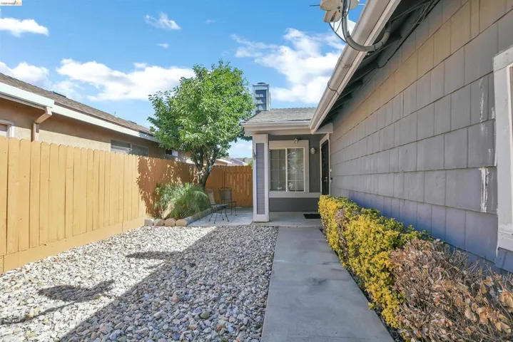Grey shingle-sided exterior with a concrete walkway