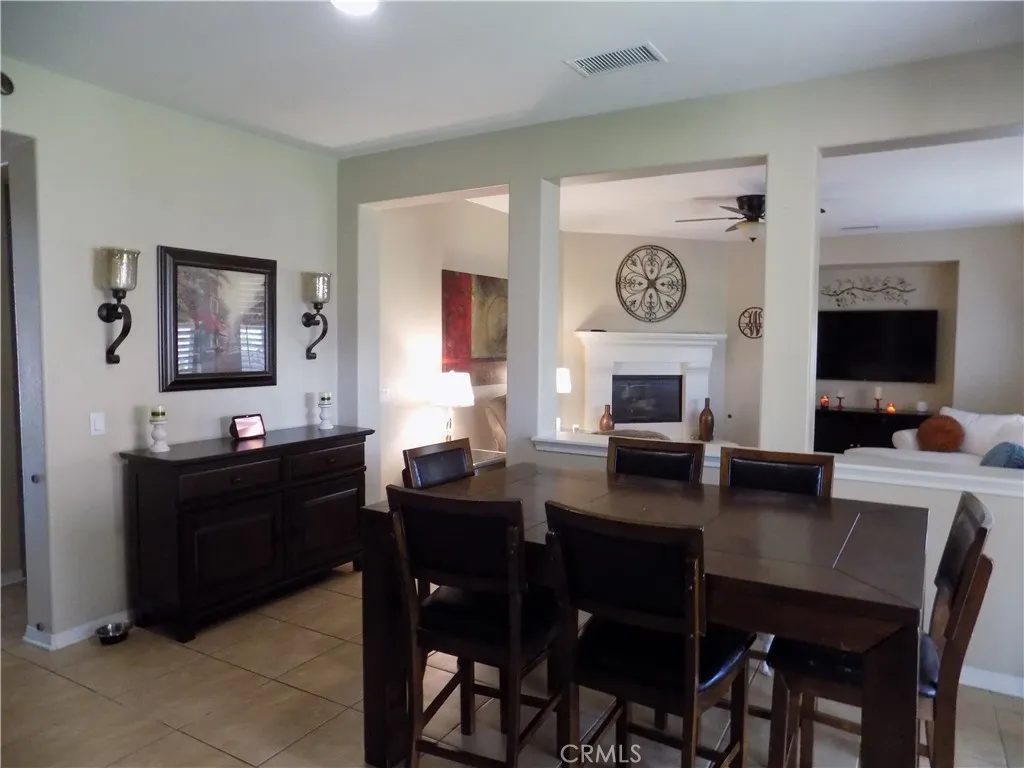 Dining area off of kitchen with adjacent family room with fireplace