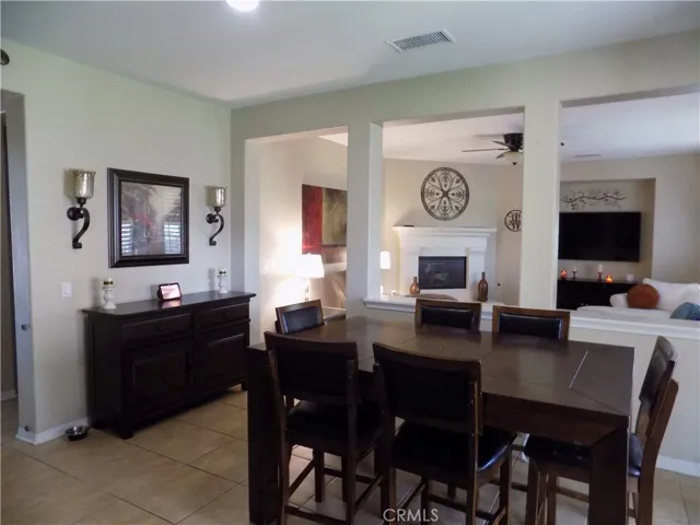 Dining area off of kitchen with adjacent family room with fireplace