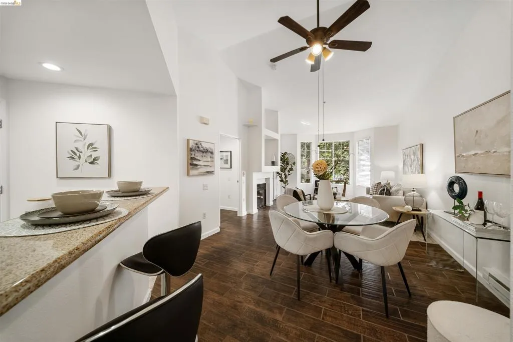 Dining space with wood finish floors, a ceiling fan, a baseboard heating unit, and a fireplace