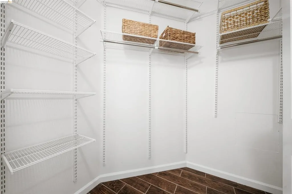 Walk in closet featuring wood finish floors