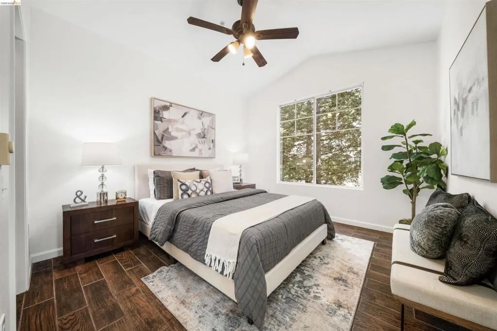 Bedroom featuring wood tiled floors, vaulted ceiling, and ceiling fan