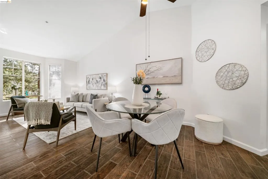 Dining room with lofted ceiling, wood tiled floors, and a ceiling fan