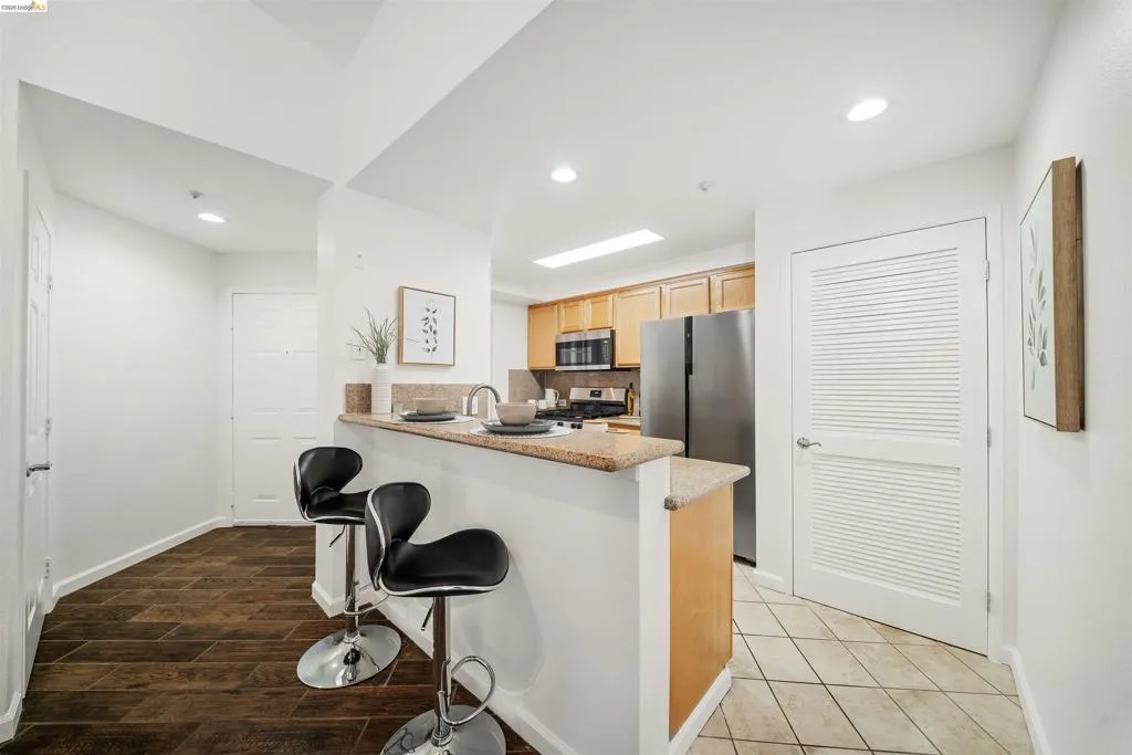 Kitchen with a peninsula, stainless steel appliances, a breakfast bar area, recessed lighting, and decorative backsplash