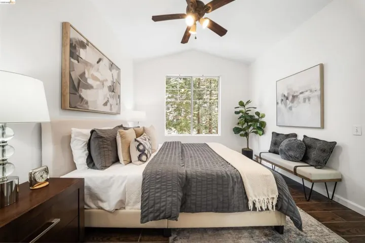 Bedroom with dark wood-type flooring, vaulted ceiling, and a ceiling fan