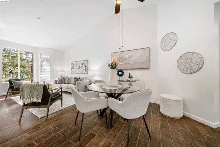 Dining room with lofted ceiling, wood tiled floors, and a ceiling fan