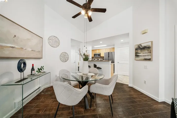 Dining room with baseboard heating, wood finish floors, recessed lighting, vaulted ceiling, and a ceiling fan