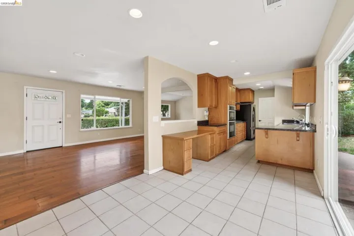 Kitchen featuring wood cabinetry, dark countertops, and integrated double ovens