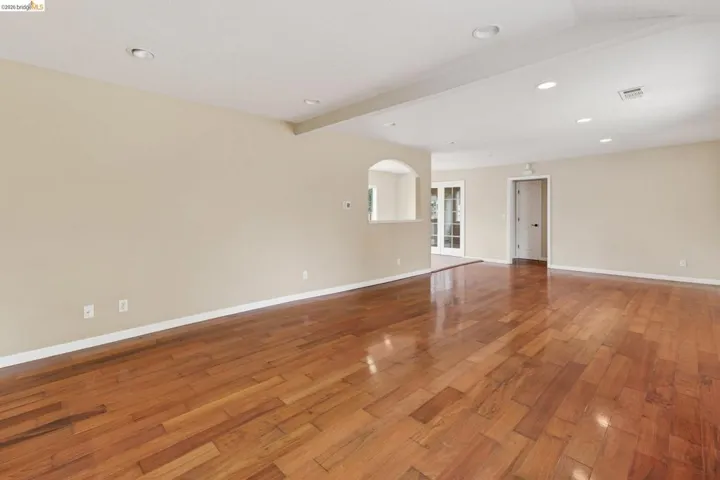 Expansive interior space featuring wood flooring, recessed lighting, and a neutral wall color