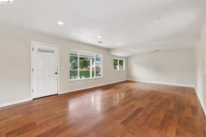 Spacious room with wood-finish flooring, recessed lighting, and expansive windows