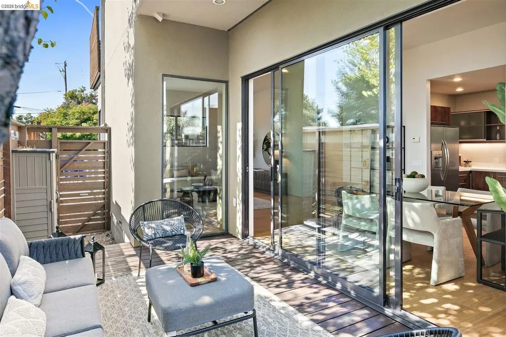 Outdoor patio featuring wood-finish decking and a slatted privacy fence