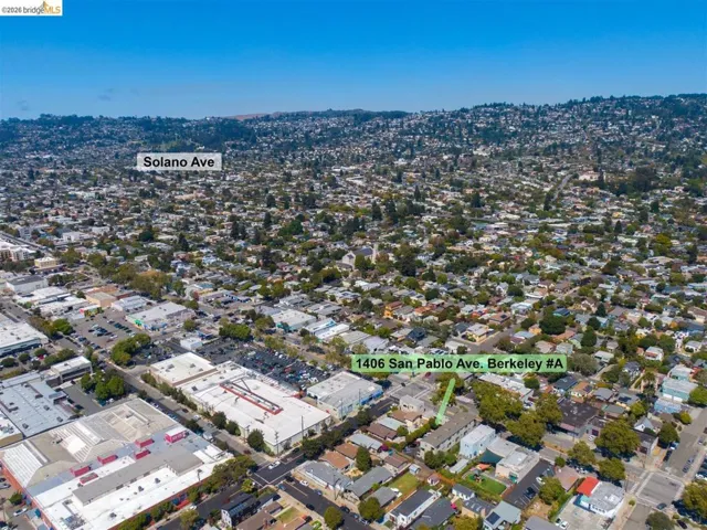Aerial perspective showcasing the surrounding residential and commercial areas, with prominent tree coverage