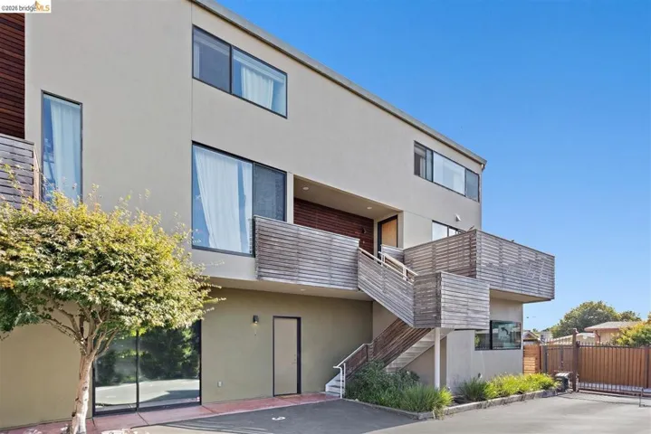 Contemporary multi-story exterior featuring stucco siding and horizontal wood panel accents