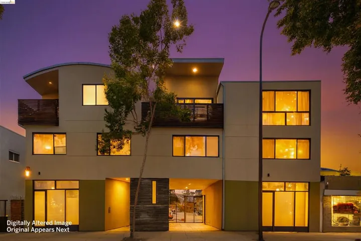 Contemporary multi-story facade featuring warm exterior lighting, multiple private balconies with wood-slat railings, and a ground-level entrance with glass doors