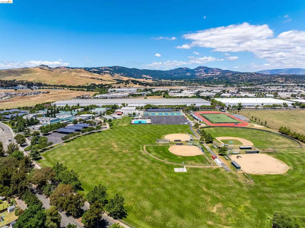 Expansive green spaces featuring multiple baseball fields, a track, and tennis courts