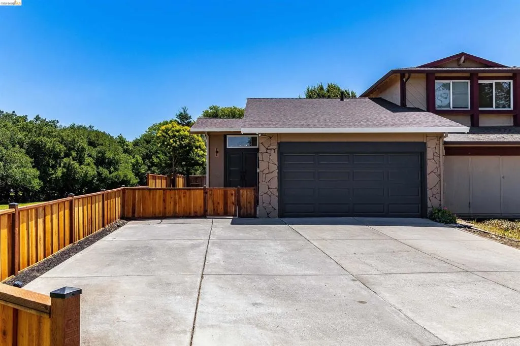 Exterior facade featuring stone accents, a two-car garage, and a concrete driveway