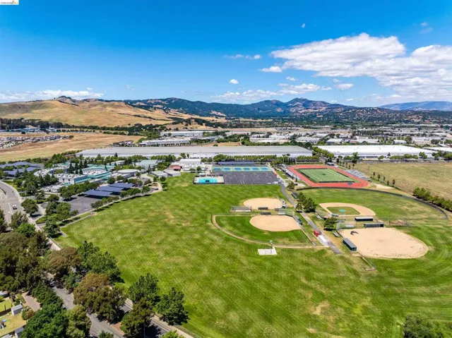 Expansive green spaces featuring multiple baseball fields, a track, and tennis courts