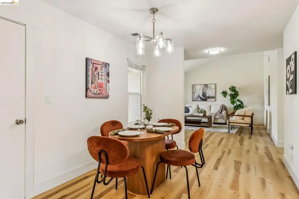 Dining area with wood-finish flooring, recessed lighting, and a modern chandelier