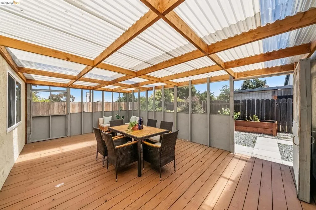 Covered patio featuring wood-finish decking and a translucent corrugated roof