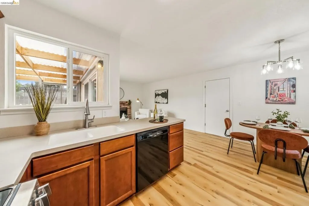 Kitchen featuring light wood-finish cabinetry, light-toned countertops, and a double basin sink