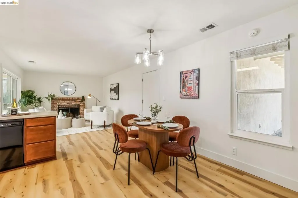 Dining area featuring wood-finish flooring and a contemporary chandelier