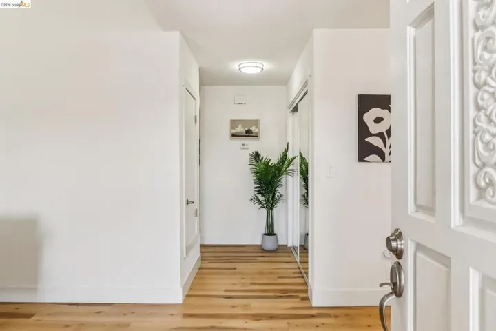 Entryway featuring light wood-finish flooring, white walls, and a decorative carved front door