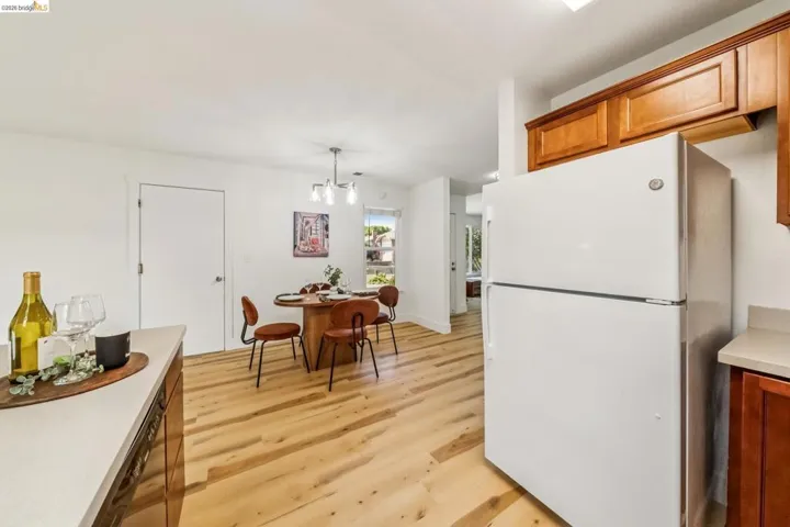 Kitchen area with wood-finish flooring, light-toned countertops, and built-in wood cabinetry